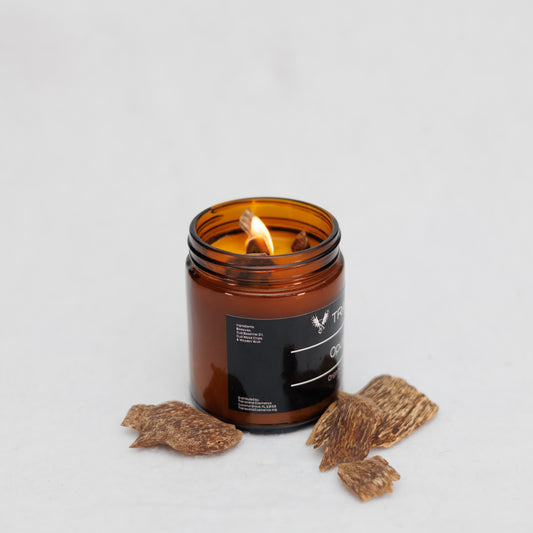 Image showing the ingredient list on the Transcend Cosmetics Opulent Oud Organic Beeswax Candle, in an amber glass jar with a wooden wick, burning with a warm flame, surrounded by Oud Wood Chips, highlighting its natural and soothing ingredients.
Ingredients are: Beeswax, Oud Essential Oil, Oud Wood Chips, & Wooden Wick. 